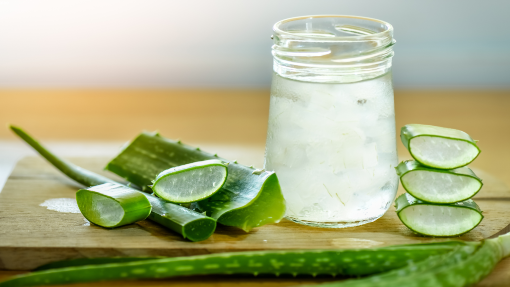 Fresh natural aloe vera in a glass jar and on a table.