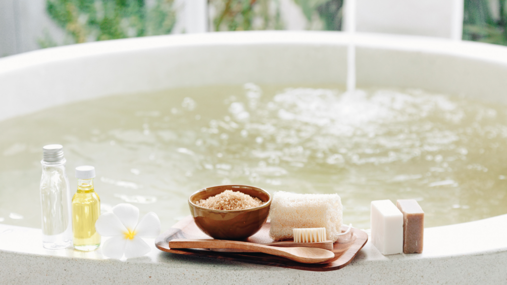 Oatmeal bath with DIY natural oatmeal soap and essential oils near a bathtub.